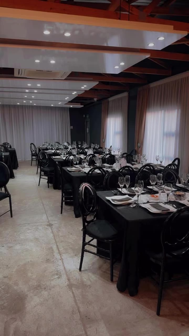 Black linen tables set for a long dinner